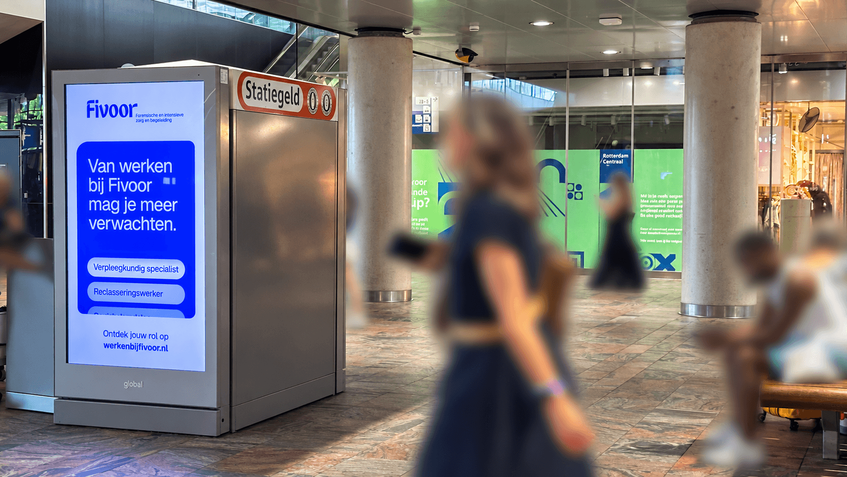 DOOH screen displaying the "Work at Fivoor" campaign next to a deposit machine in a train station concourse