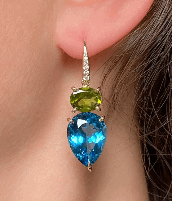 Oorhanger van Manon Herrewijnen met een groene peridot en een blauwe topaas